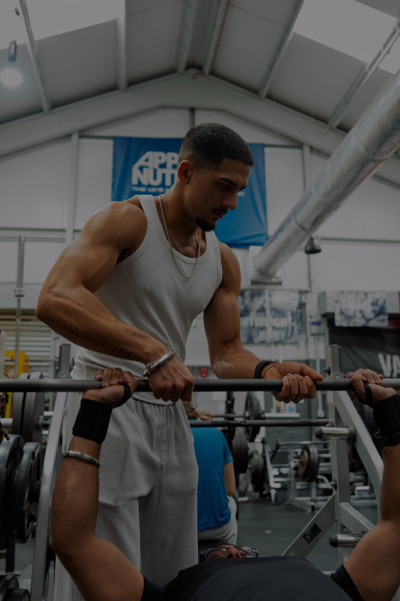 Haridev supporting a client during a bench press